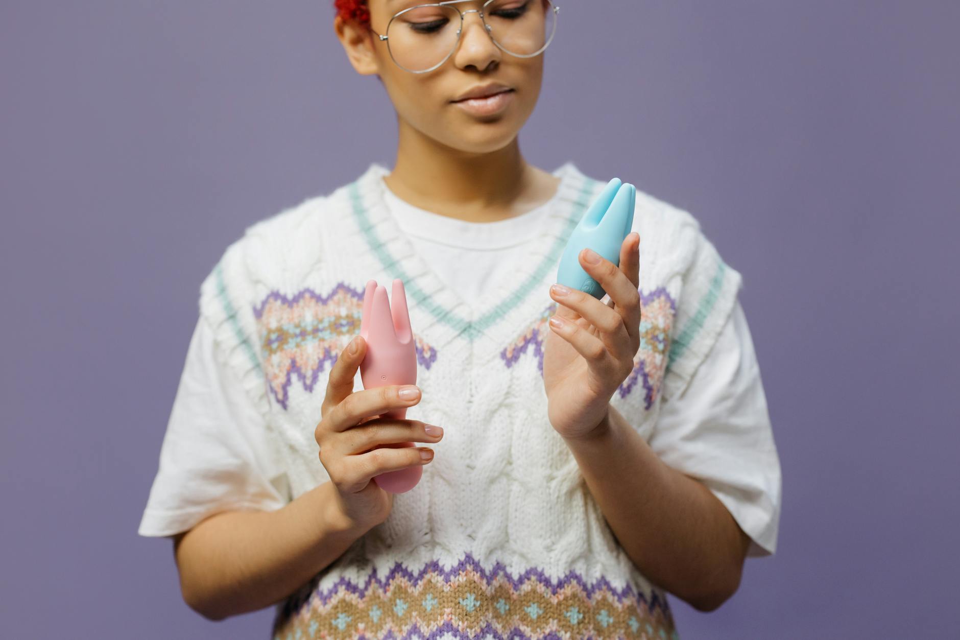 Woman holding lemon clitoral vibrators in contemplative moment.