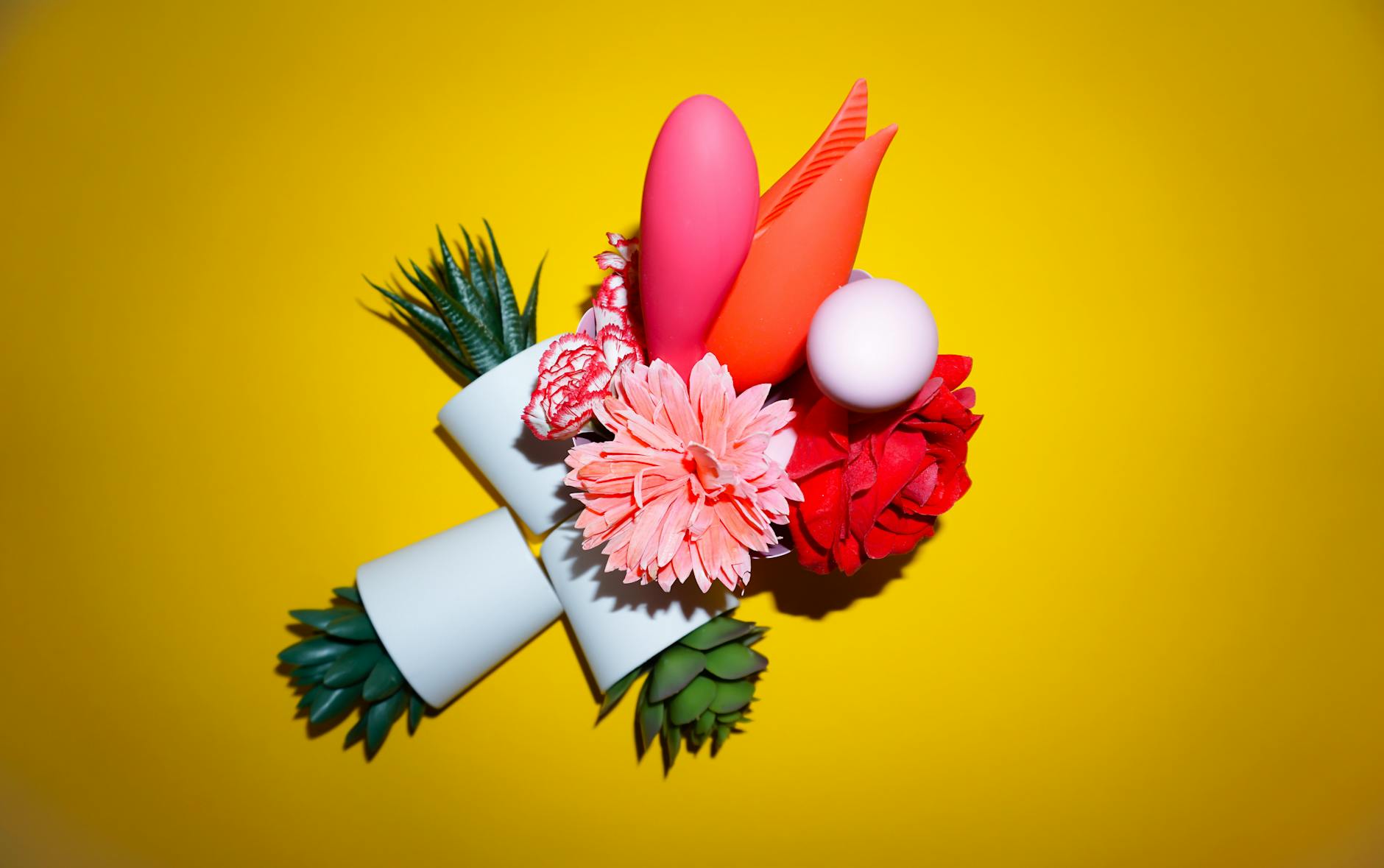 Colorful arrangement of intimate wellness products on a bright yellow background
