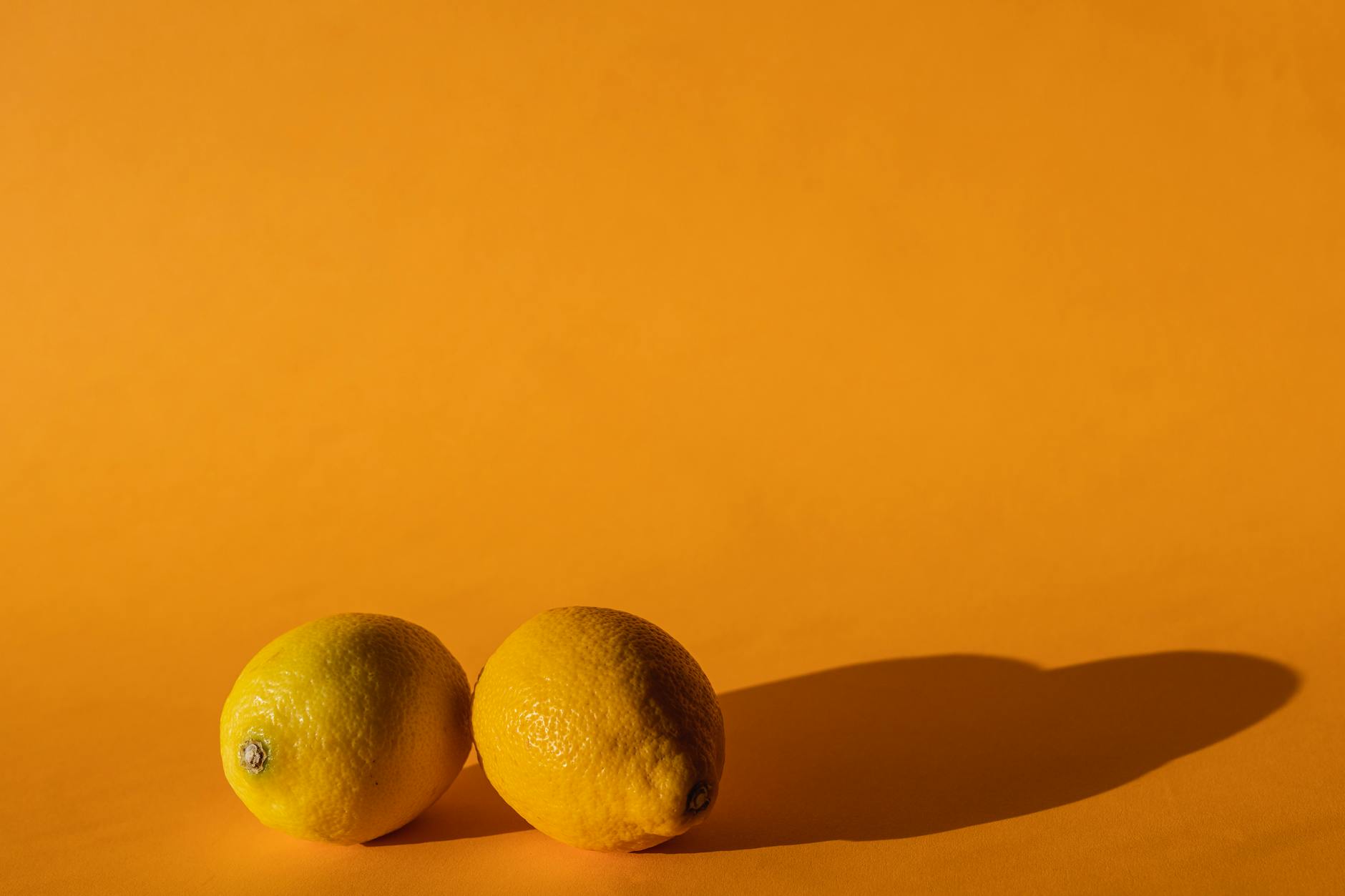Ripe vivid lemons on a bright yellow background, symbolizing heightened sensitivity and intensity
